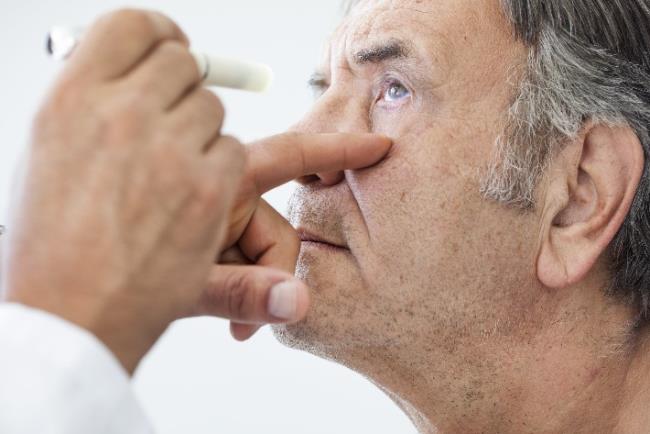 אדם מבוגר אשר סובל מקטרקט בבדיקה אצל רופא העיניים