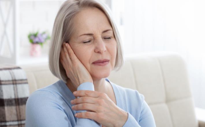 אישה מבוגרת סובלת מדלקת באוזניים