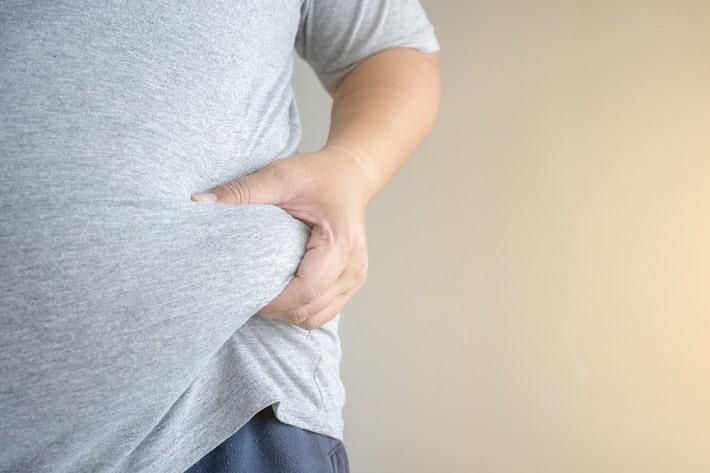 איש הסובל מהשמנת יתר אוחז בשומן הבטני, השמנה וסרטן