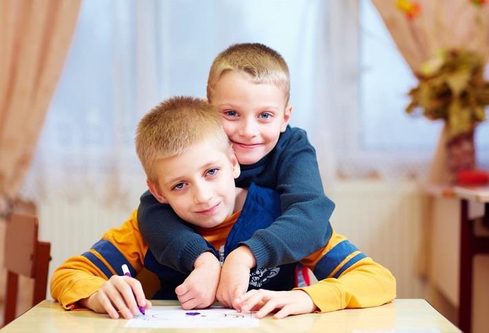 ילד עם היפוטוניה מחבק את אחיו בידיים רופסות 