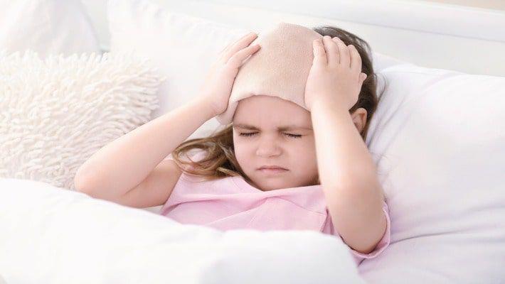 ילדה עם דלקת קרום המוח סובלת מכאב ראש