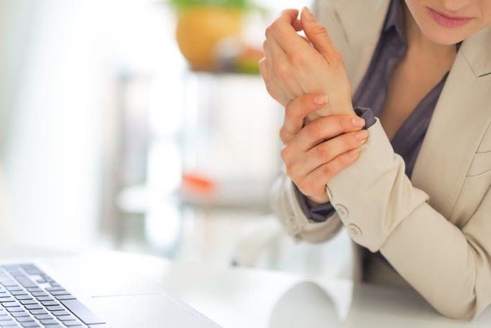 אישה עם כאב במפרק היד זקוקה לאטודולק אטופן