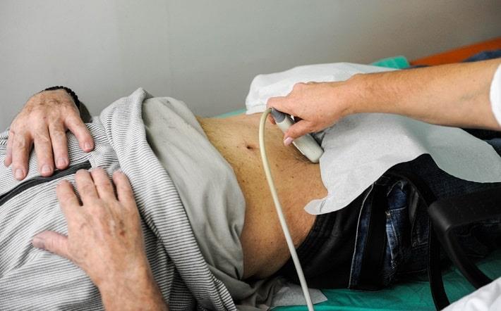 רופא מבצע אולטרסאונד בבטן במטופל מבוגר שעומד לעבור ביופסיית כבד