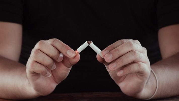 גבר שובר סיגריה כחלק מתהליך טיפול גמילה מעישון