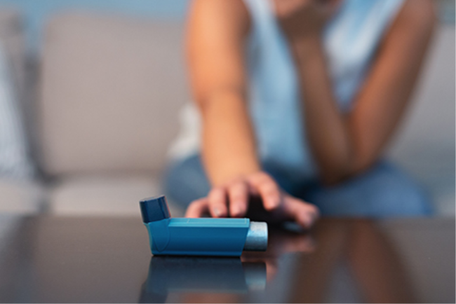 אישה מושיטה יד למשאף כי סובלת מהתקף אסתמה 