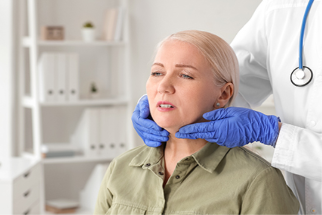 רופא בודק לאישה את בלוטות הלימפה הצוואריות, סימן אזהרה ללימפומה