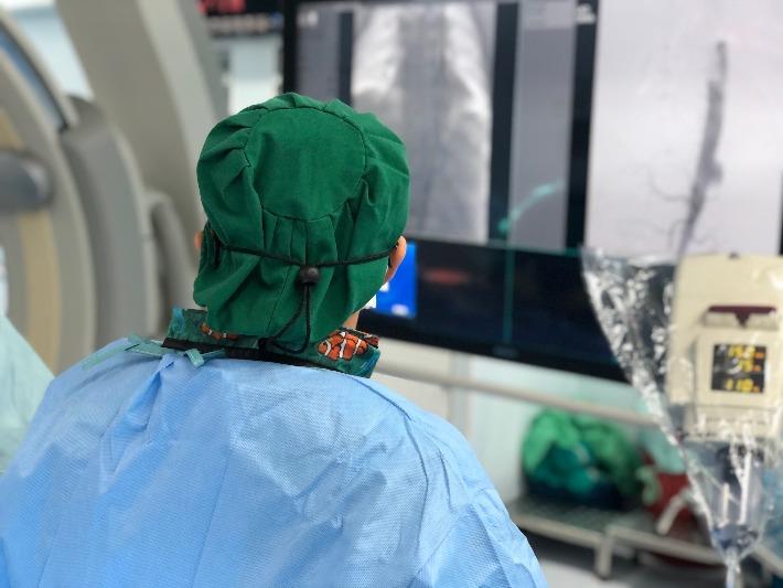 מנתח בוחן צילום רנטגן לפני ההחלטה על טיפול במפרצת אבי העורקים הבטני