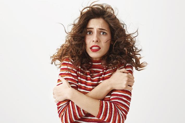 אישה מחבקת את הזרועות כדי להקל על הצמרמורת 