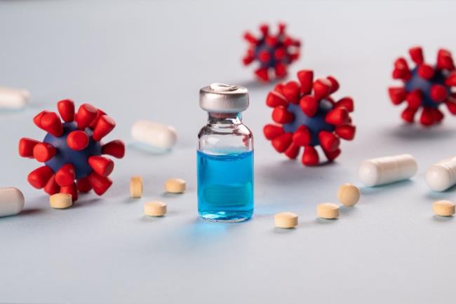 אילוסטרציה, תרופה הניתנת בהזרקה וסביבה דגמים של נגיף הקורונה החדש