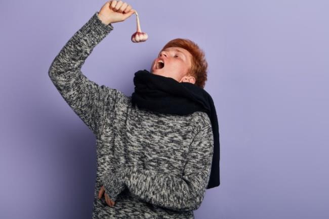 גבר צעיר חולה אוכל שום כתחליף טבעי לאקונומיקה