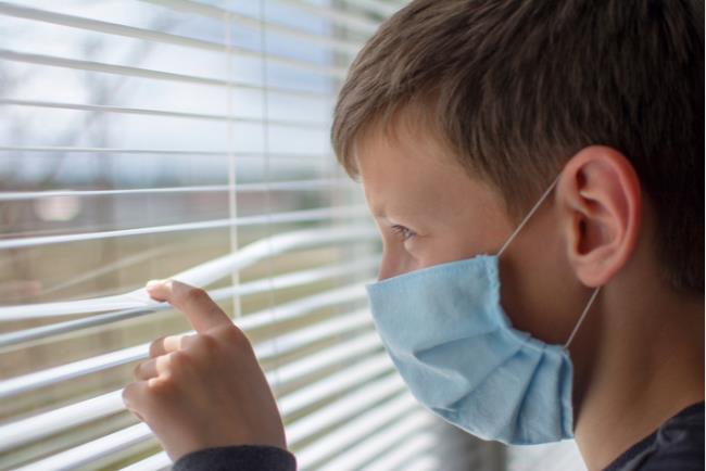 מתבגר הסובל מחרדה חברתית מביט החוצה מהחלון 