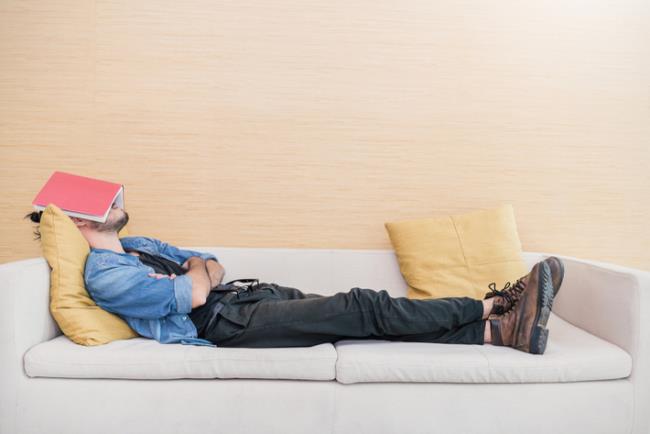 אדם ישן במהלך היום ועל ראשו ספר