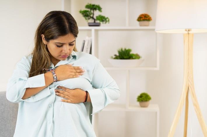 אישה מבצעת בדיקה עצמית לגילוי סרטן השד ומגלה דליפת נוזל 