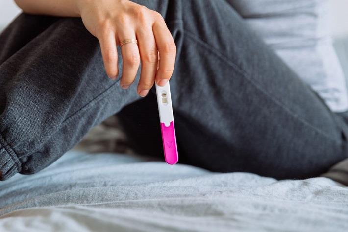 יד של אישה אוחזת בבדיקת היריון ביתית שלילית