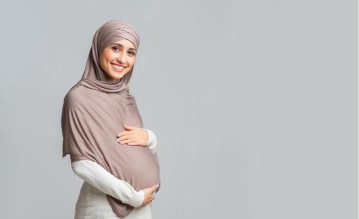 אישה ערביה בשבוע 19 להריון אוחזת את בטנה