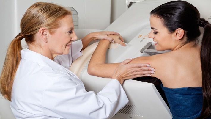 רופאה מדריכה אישה צעירה לפני בדיקת ממוגרפיה לגילוי סרטן השד