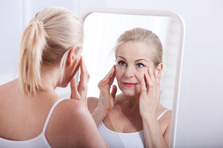 אישה מבוגרת בוחנת את הפנים ומתלבטת על ניתוח למתיחת פנים