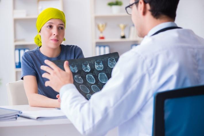 אישה צעירה מדברת עם רופא אונקולוג לגבי טיפול מותאם אישית בסרטן 