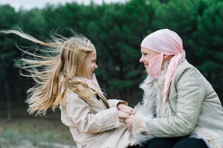 אישה צעירה חולת הסרטן נהנת מיום בטבע עם ביתה כחלק מנסיון השמירה על איכות החיים במהלך הטיפול האונקולוגי 