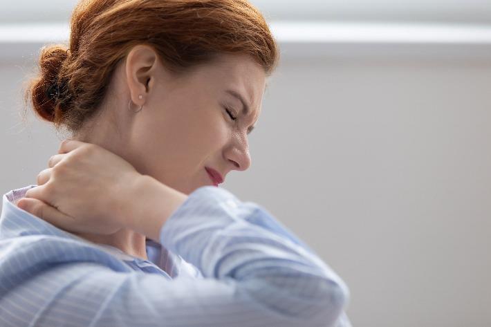 אישה סובלת מכאבי צוואר הנובעים מפיברומיאלגיה