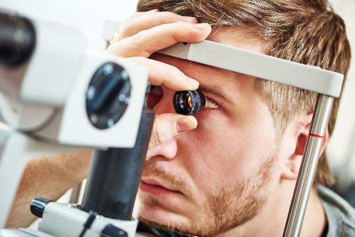 גבר צעיר עובר בדיקת עיניים בגלל חשד לרטינופתיה נסיובית מרכזית