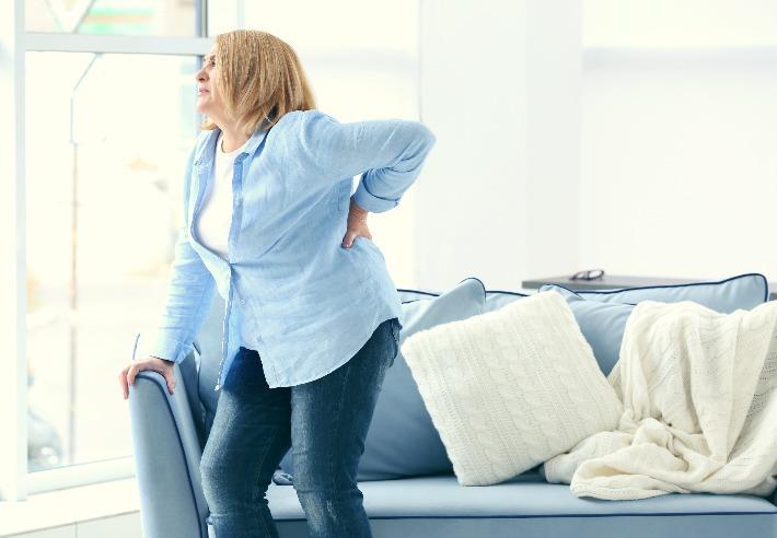 אישה סובלת מכאבי גב כרוניים שיכולים להיות מטופלים ביעילות באמצעות קנאביס רפואי