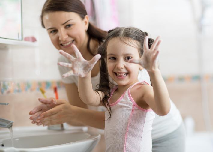 אמא וילדה שוטפות את הידיים כאמצעי למניעת הידבקות בקורונה 
