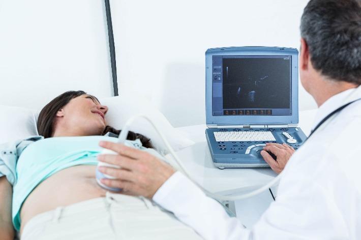 אישה עוברת בדיקת שקיפות עורפית מורחבת במהלך ההריון