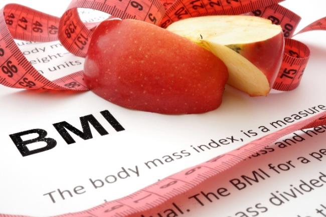 סרט למדידת היקפים וחתיכות תפוח על דף הסבר על מדד ה-BMI 