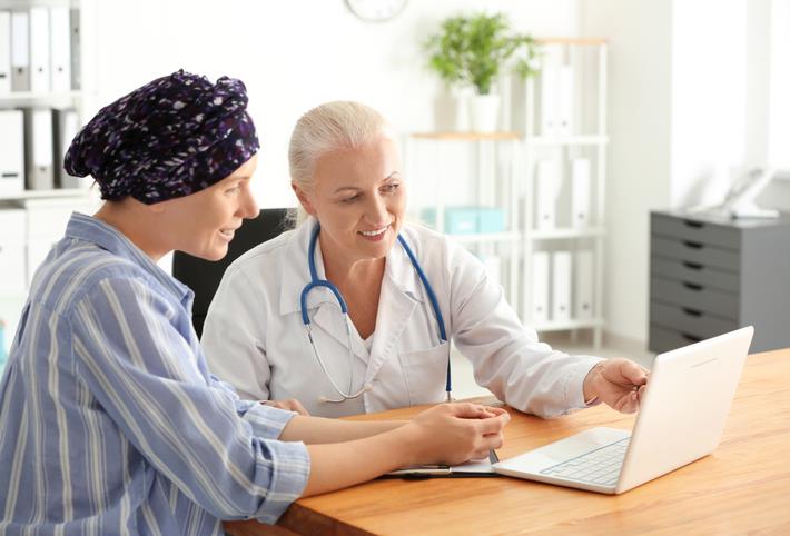 רופא מדבר עם מטופלת לגבי טיפול מותאם אישית בסרטן השד