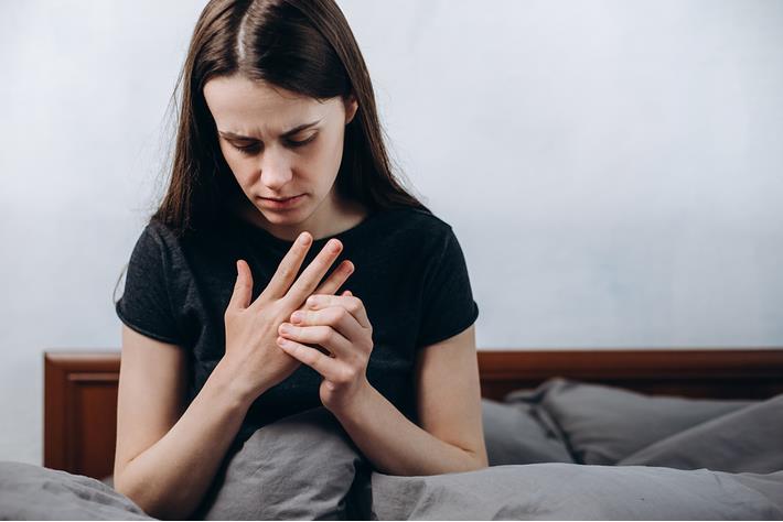 אישה סובלת מנוקשות באצבעות הידיים