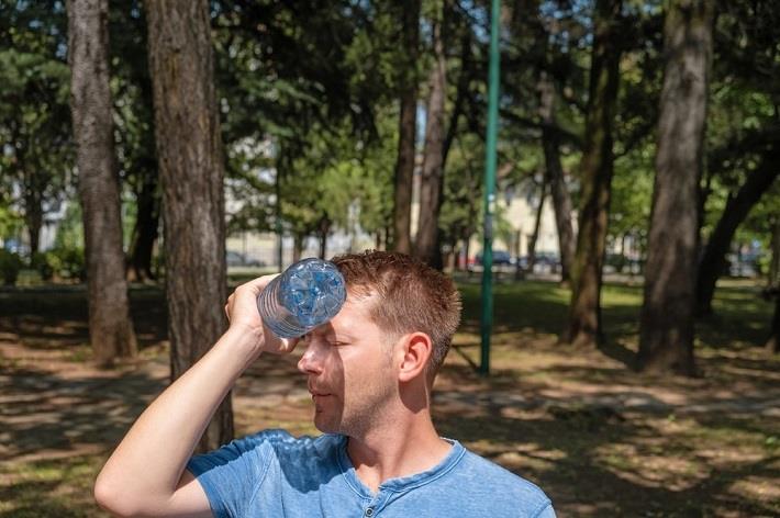 גבר מחמם את עצמו עם בקבוק מים בשל שינויי האקלים