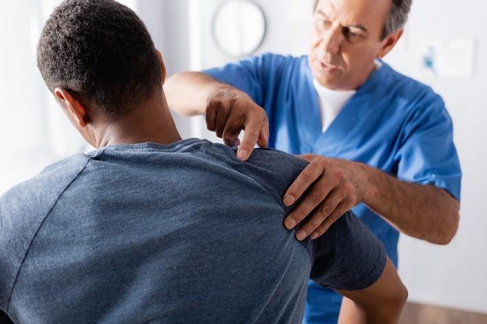 כירופרקט מטפל בבחור עם בעיות בכתף, טיפולים משלימים לבעיות אורתפדיות