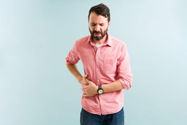 גבר עם כאבים בצד סובל מאבנים בכיס מרה, חומצה אורסודאוקסיכולית