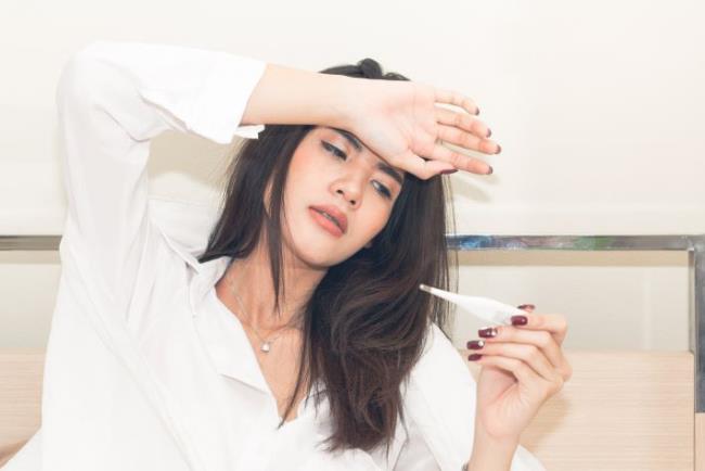 בחורה עם שפעת מודדת חום, פרצטמול (אקמול, דקסמול)