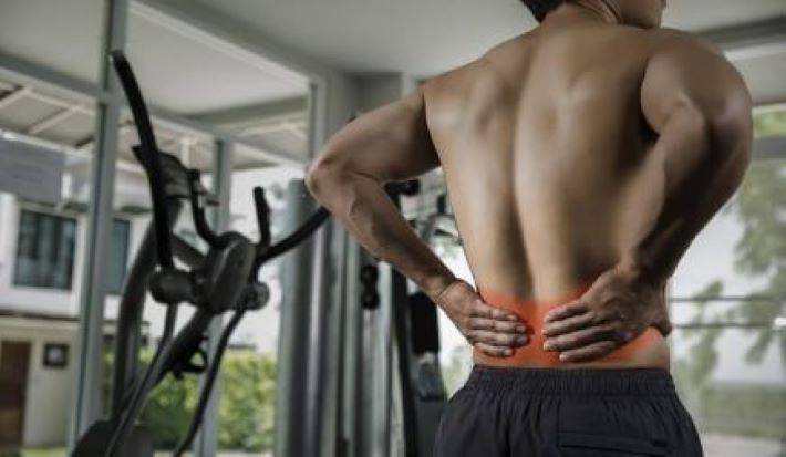 גבר בחדר כושר סובל מכאב גב, טרגין