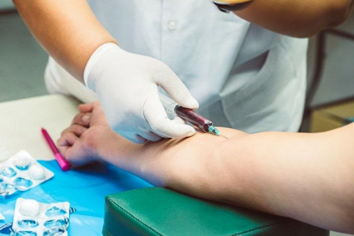 ידיים של אח דוגמות דם מזרוע מטופל לצורך בדיקת דם, רמת ווריקונזול בדם   