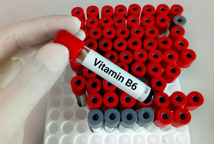 יד אוחזת במבחנה עם דם של בדיקת ויטמין B6