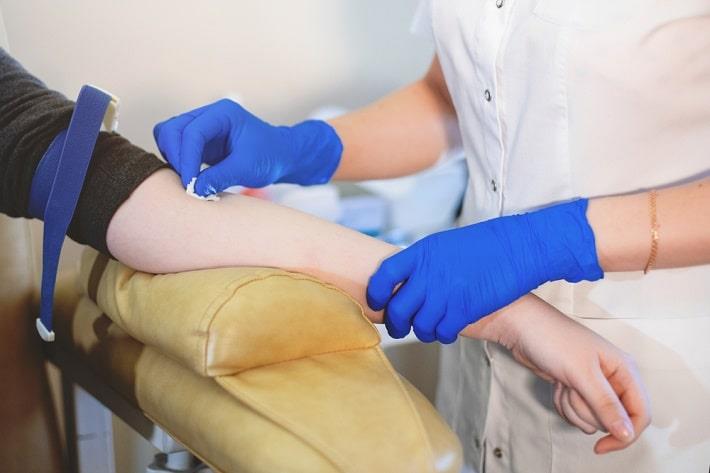 אחות מחטאת דרועה של מטופלת רגע לפני לךקיחת דם לצורך בדיקת פאנל נוגדנים פאראנאופלסטי 