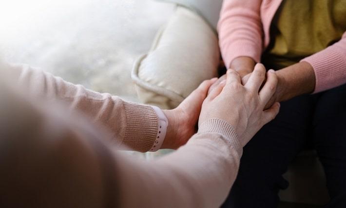 מטפלת אוחזת בידה של מטופלת מבוגרת, טיפול רגשי למבוגרים