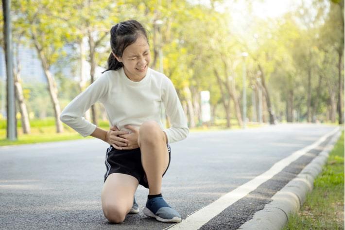 ילדה סובלת מכאבי בטן עזים באמצע ריצה בגלל אפנדציטיס