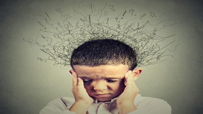 ילד הסובל מ-ADHD הפרעות קשב וריכוז, אוחז את ראשו