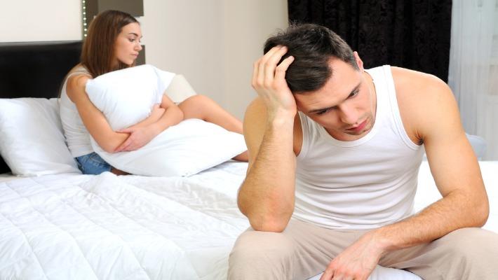 גבר ואישה יושבים על המיטה מודאגים בגלל הפה חוזרת
