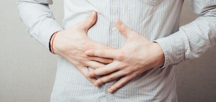 גבר מחזיק את הבטן, סובל מחיידק הליקובקטר פילורי בקיבהלנטון, לנסופרזול