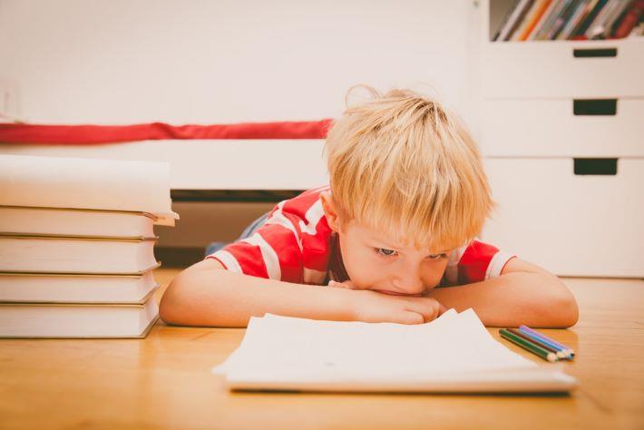 ילד עם ADHD שוכב ומביט בדפים ריקים, ויואנס