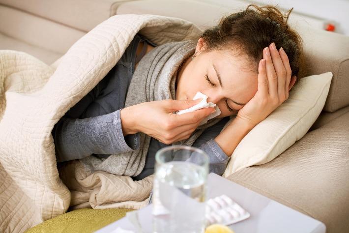 אישה סובלת מתסמינים חריפים של שפעת וזקוקה לתקופה תרופתית