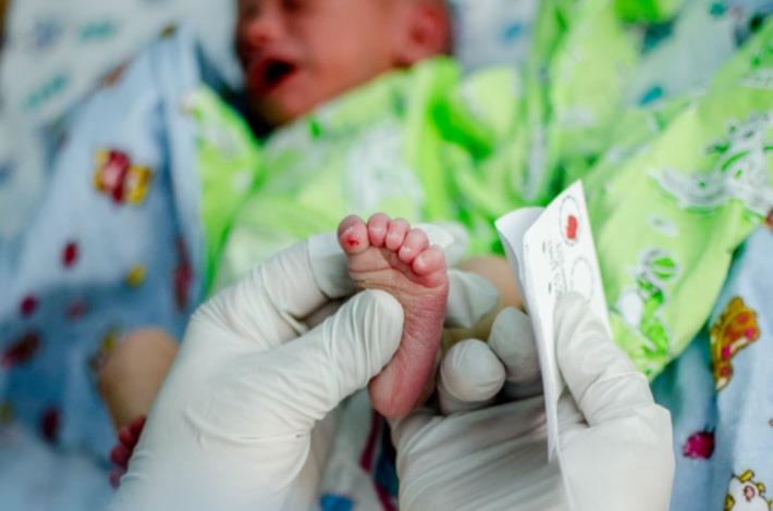 אחות מבצעת בתינוק בדיקת דם מסוג חומצות שומן ארוכות שרשרת VLCFA