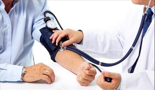 רופא עם סטטוסקופ בודק יתר לחץ דם במטופל