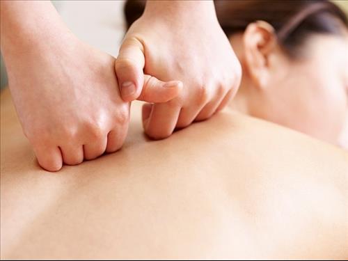 תקריב של ידיים על גב אישה בעת טיפול טווינא