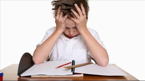 ילד הסובל מהפרעות קשב וריכוז ADHD יושב מתוסכל מול ספר
